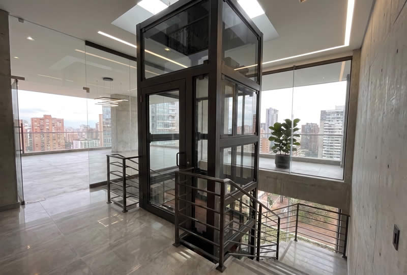 Descubra ya elevadores de vidrio junto a las escaleras y solicite asesoría experta para una solución segura, moderna y confiable con Ascensores Fahenn en Bogotá, Colombia
