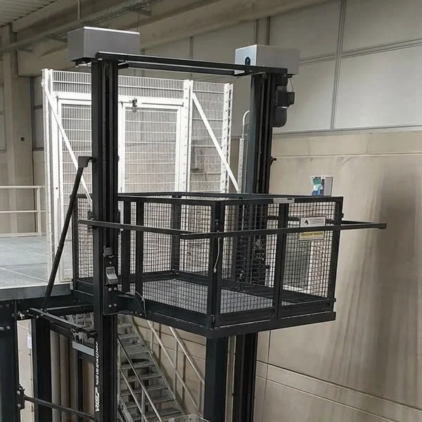 Plataforma de carga industrial instalada entre dos niveles de una planta, con cabina abierta, cerramiento metálico y accesos protegidos en Bogotá, Colombia