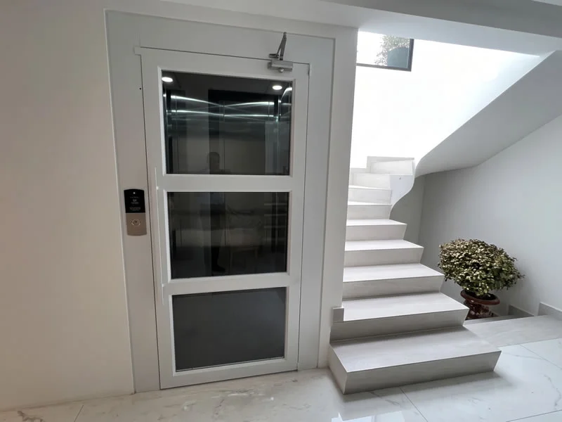 Descubra un ascensor para casa instalado junto a escaleras con diseño compacto y encuentre una solución moderna y funcional, con soluciones confiables en Bogotá, Colombia