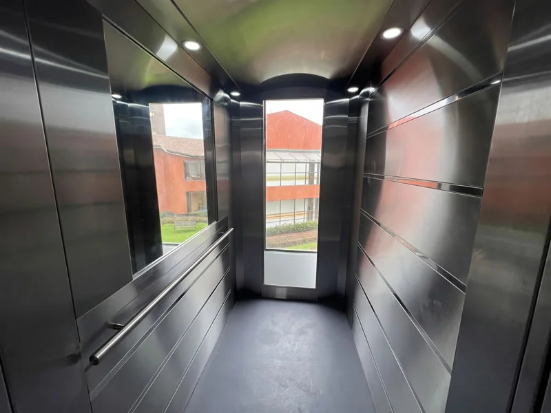 Descubra una cabina panorámica de ascensor con ventanales y pasamanos elegantes y encuentre una solución moderna y funcional, con seguridad y respaldo en Bogotá, Colombia