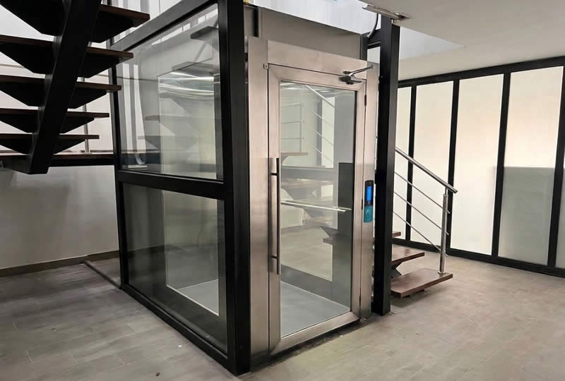 Explore un ascensor residencial con cabina en vidrio y acero, dise&ntilde;ado para integrarse de manera moderna y segura en casas en Bogot&aacute;, Colombia. Ascensores Fahenn