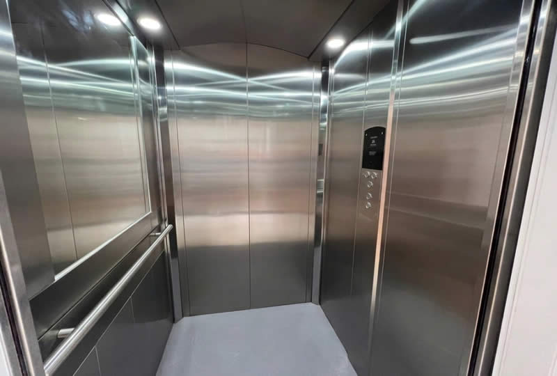 Explore una cabina de ascensor en acero inoxidable con espejo, pasamanos y acabados de alta calidad para uso cotidiano en Bogot&aacute;, Colombia. Ascensores Fahenn