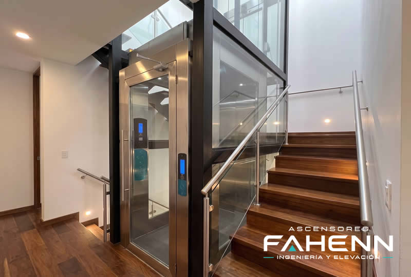 Descubra un ascensor residencial panor&aacute;mico junto a las escaleras, con cabina de vidrio y dise&ntilde;o actual; pida asesor&iacute;a para su casa en Bogot&aacute;, Colombia. Ascensores Fahenn